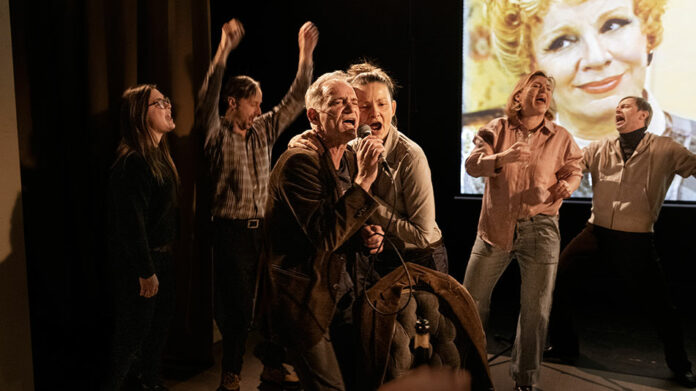 V prologu sledujeme divadelnický mejdan s promítáním úryvků ze slovenské televizní inscenace Krkavců ve stylu rané belle époque. Dejvický soubor slovenské herce živě dabuje, dabing se ovšem od pohybů úst postupně stále více odpoutává a z promítaných scén si utahuje. Foto Patrik Borecký