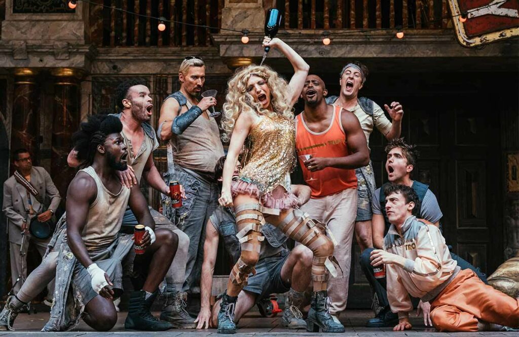 Troilus a Kressida: Groteskně vyhrocená interpretace s prvky kabaretu v Globu. Obraz civilizace ve fázi rozkladu je tím, co v Shakespearově „nehratelném“ dramatu odkrývá vysoce aktuální téma. Krásnou Helenu i cynického šeredu Thersita ztvárnila punkerská Lucy McCormick (uprostřed). Foto Helen Murray